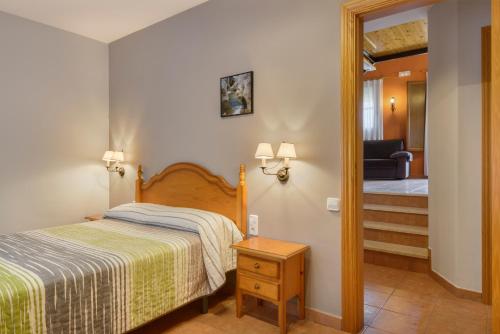 a bedroom with a bed and a door leading to a hallway at Apartamentos Casa Aurelia in Alquézar