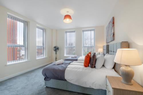um quarto com uma cama grande e janelas em SPECIAL OFFER!! Wednesbury, 1& 2 Bedroom Apartments with Private Parking by 12Stay em Wednesbury