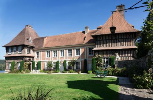 una grande casa con un grande cortile erboso di Les Suites Château du Breuil Normandie a Le Breuil-en-Auge