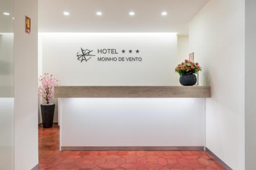 a sign for a hotel with flowers on a wall at Hotel Moinho De Vento in Viseu