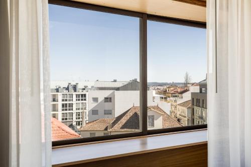 uma janela com vista para uma cidade em Hotel Moinho De Vento em Viseu