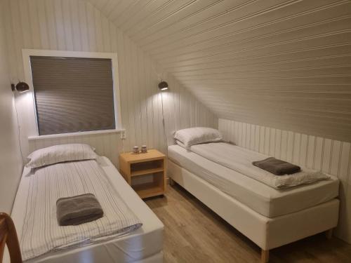2 łóżka w małym pokoju z oknem w obiekcie Flaga 2 Guesthouse w mieście Hrífunes 