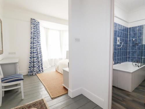 a bathroom with a tub and a bedroom with a bed and a bath tub at Melvill House in Falmouth