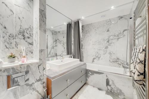 Baño blanco con lavabo y bañera en The Princes Residences en Londres