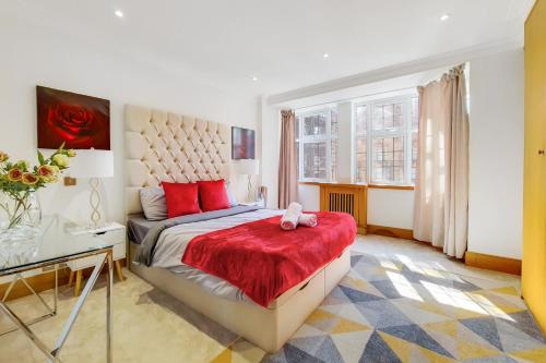 1 dormitorio con 1 cama con manta roja en The Princes Residences en Londres