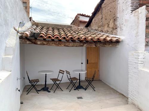un patio con 2 mesas y sillas en un edificio en Cal Torrentó Apartaments, en Balaguer
