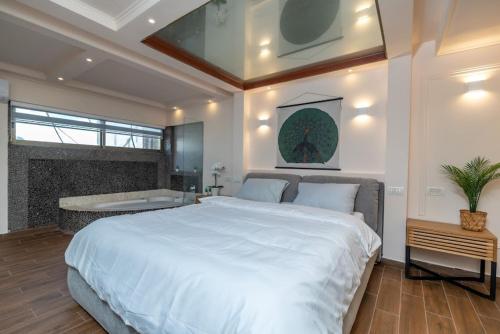 - une chambre avec un grand lit blanc et une baignoire dans l'établissement נירוונה פנטהאוז יוקרתי לאירוח ונופש, à Netanya