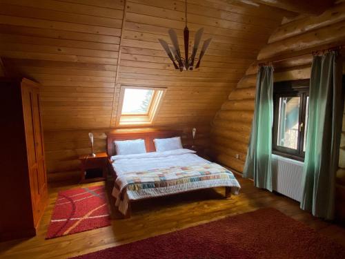 a bedroom with a bed in a wooden cabin at Cabana 33 in Predeluţ