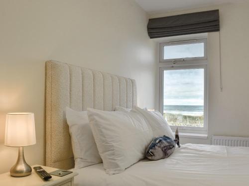 1 dormitorio con 1 cama y ventana con vistas al océano en Cremona Cottage, en Carlin How