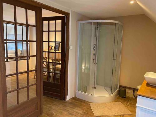 ein Bad mit einer Dusche und einer Glastür in der Unterkunft Chez Trudi Charmante maison à la campagne in Livry
