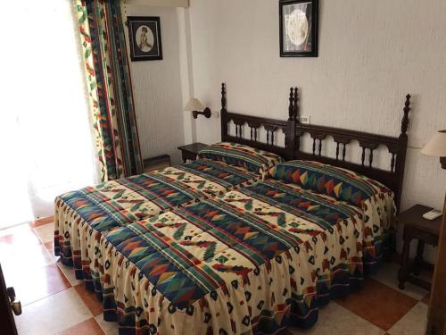 een slaapkamer met een groot bed en een kleurrijk dekbed bij Two Bed in the Manga in La Manga del Mar Menor