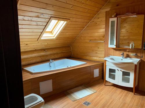 a bathroom with a tub and a sink and a toilet at Chalet 33 - Spacious, cosy and a wonderful view in Predeluţ