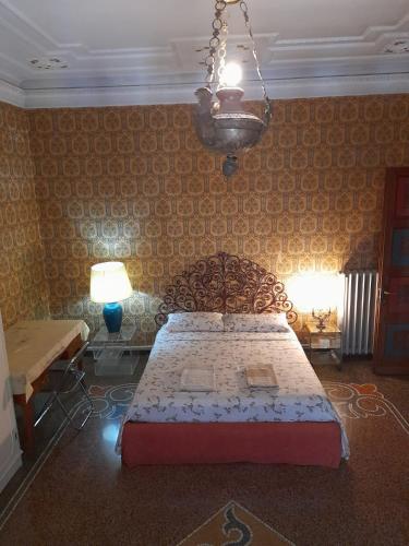 a bedroom with a bed and a chandelier at Le Stanze del Notaio in Genova
