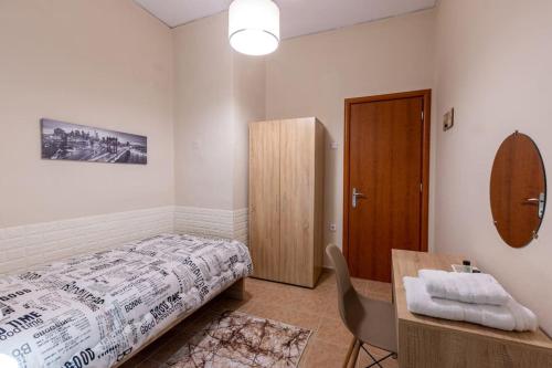 a bedroom with a bed and a desk and a chair at Anna's House in Komotini