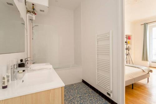 a white bathroom with a sink and a bed at SLEEPOO - Paradise 6 in Paris