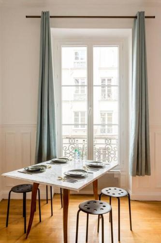 une table blanche avec deux chaises et une fenêtre dans l'établissement SLEEPOO - Paradise 8, à Paris