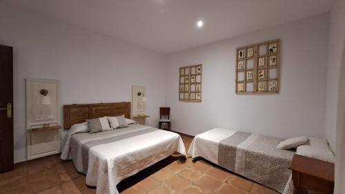 2 camas en una habitación con paredes blancas en Mirador del Sotillo, en Cazalla de la Sierra