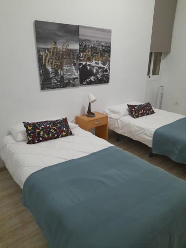 a bedroom with two beds and a picture on the wall at San Sebastián 65 in Santa Cruz de Tenerife