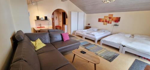 ein Wohnzimmer mit einem Sofa und 2 Betten in der Unterkunft ciao-aschau FeWo Schöne-Aussicht in Aschau