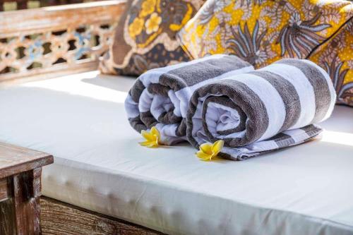 une pile de serviettes assises sur un lit dans l'établissement Tano Home Villas, à Ubud