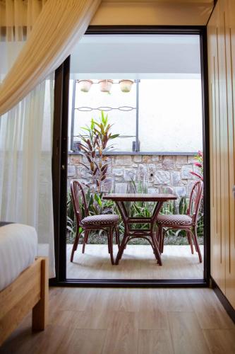 a room with a table and chairs on a patio at Saphir Boutique Hotel in Kigali
