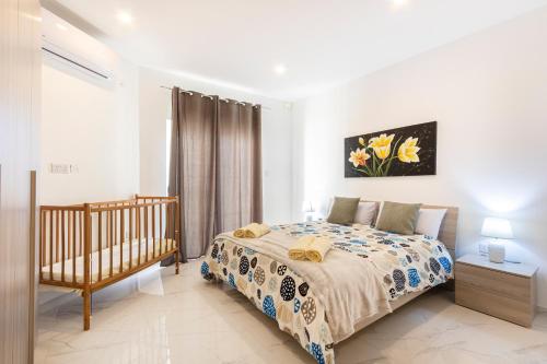 a bedroom with a bed and a crib at H1- Modern & Spacious 3 Bedroom Apartment in San Ġwann