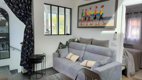 a living room with a gray couch and a painting at Le Refuge, 2 personnes, 4 étoiles tout confort in Annecy-le-Vieux