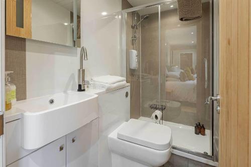 a bathroom with a toilet and a sink and a shower at Garthill Lodge & Studio in Falkirk