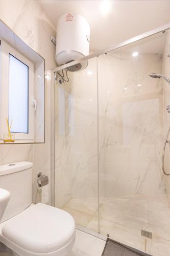 a white bathroom with a shower and a toilet at H1- Modern & Spacious 3 Bedroom Apartment in San Ġwann