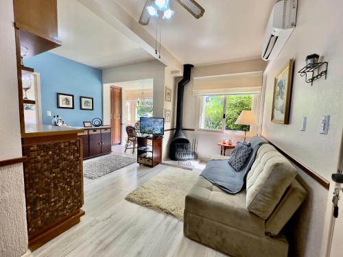 uma sala de estar com um sofá e uma cozinha em Apartamento c/LAREIRA CONDOMÍNIO, próx LAGO NEGRO em Gramado