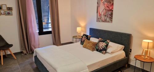 a small bedroom with a bed with two lamps at Le Mandarin, appartement climatisé, centre-ville à moins de 10min à pied, Saint Paul, 4 personnes in Saint-Paul