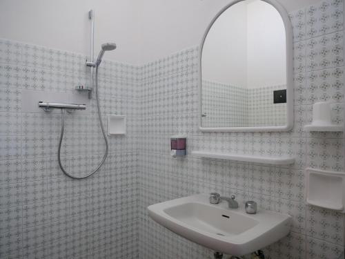 ein Bad mit einem Waschbecken und einer Dusche mit einem Spiegel in der Unterkunft Hotel Pari in Misano Adriatico