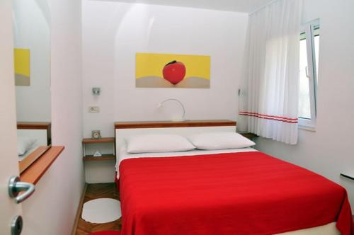 1 dormitorio con cama roja y manta roja en Apartment Mili - with sea view en Split