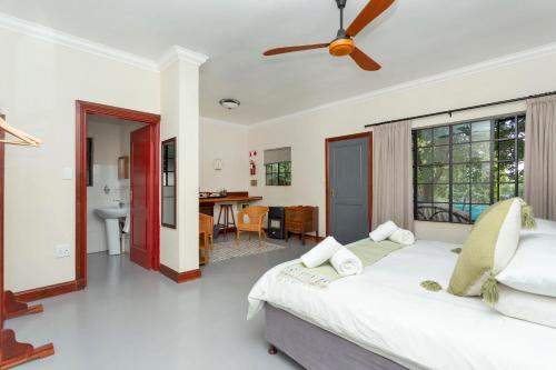 a bedroom with a bed with a ceiling fan at Teak Place Guest Rooms in Krugersdorp