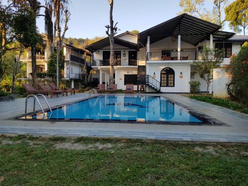 a swimming pool in front of a house at Ella Forest Paradise Hotel in Ella