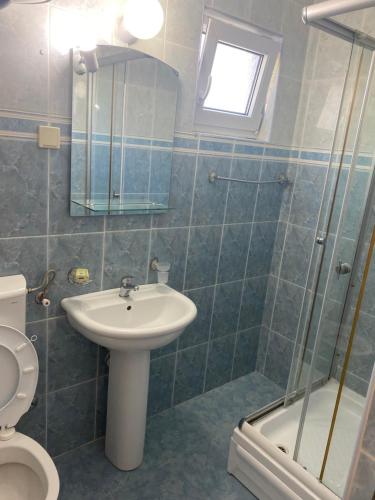 uma casa de banho com um lavatório, um WC e um chuveiro em Guest house Perović em Sutomore
