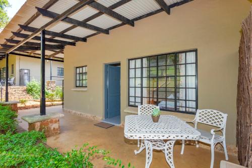 a patio with a table and chairs on a patio at Teak Place Guest Rooms in Krugersdorp