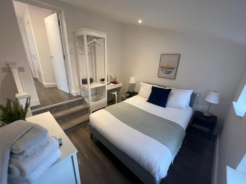 um quarto com uma cama branca e um espelho em Corner Stone House - Apartment 1 em Great Yarmouth