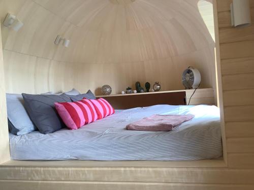 a bed with pink and blue pillows on it at SkyFall in Woodbridge