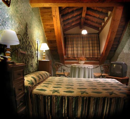 a bedroom with a bed and a table in a room at Posada el Zaguan in Turégano