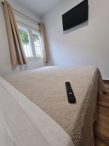 a remote control sitting on top of a bed at Hostal Santa Ana in Huelva