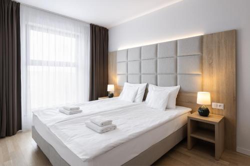 sypialnia z dużym białym łóżkiem i oknem w obiekcie Green Apartments w mieście Karpacz