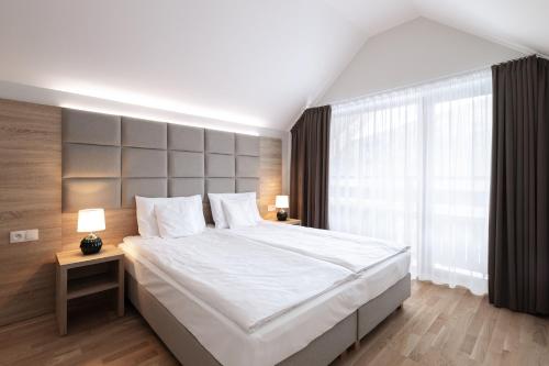 a bedroom with a large bed and a large window at Green Apartments in Karpacz
