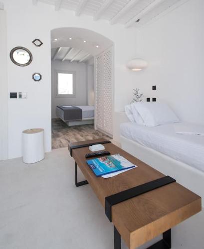 a white bedroom with a bed and a table at Cloe Cycladic Residence, by Mykonos High in Mýkonos City