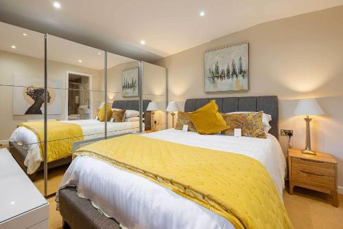 a bedroom with two beds with yellow pillows at Garthill Lodge & Studio in Falkirk