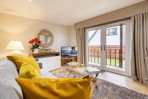 a living room with a couch and a tv at Garthill Lodge & Studio in Falkirk