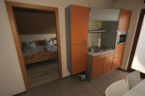 a small kitchen with a bed in a room at Pension Zum Paradies in Harthausen