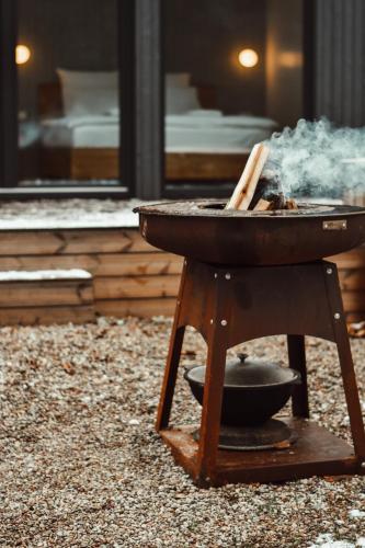 a grill with a pan on a stand with smoke at Poilsio nameliai - B E L A I K O in Kretinga