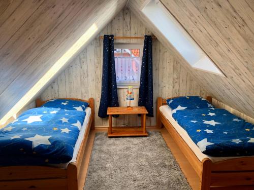 two beds in a attic room with a window at Möwennest in Krummhörn