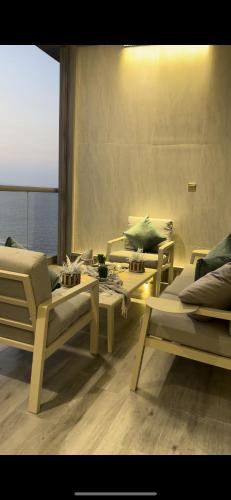a room with couches and tables and a view of the ocean at برج داماك الجوهرة جدة - Damac al jawharah tower in Jeddah